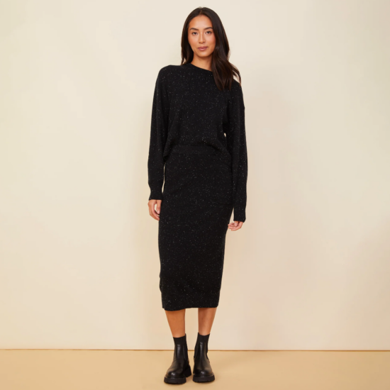 The model is wearing a black sweater and Neps Cashmere Pocket Midi Skirt.