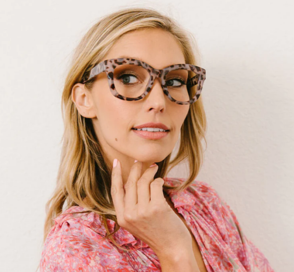 A woman in a pink top and Peepers Center Stage Progressive glasses is posing for a photo.