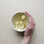 A cup of tea with ginger and lemon in it