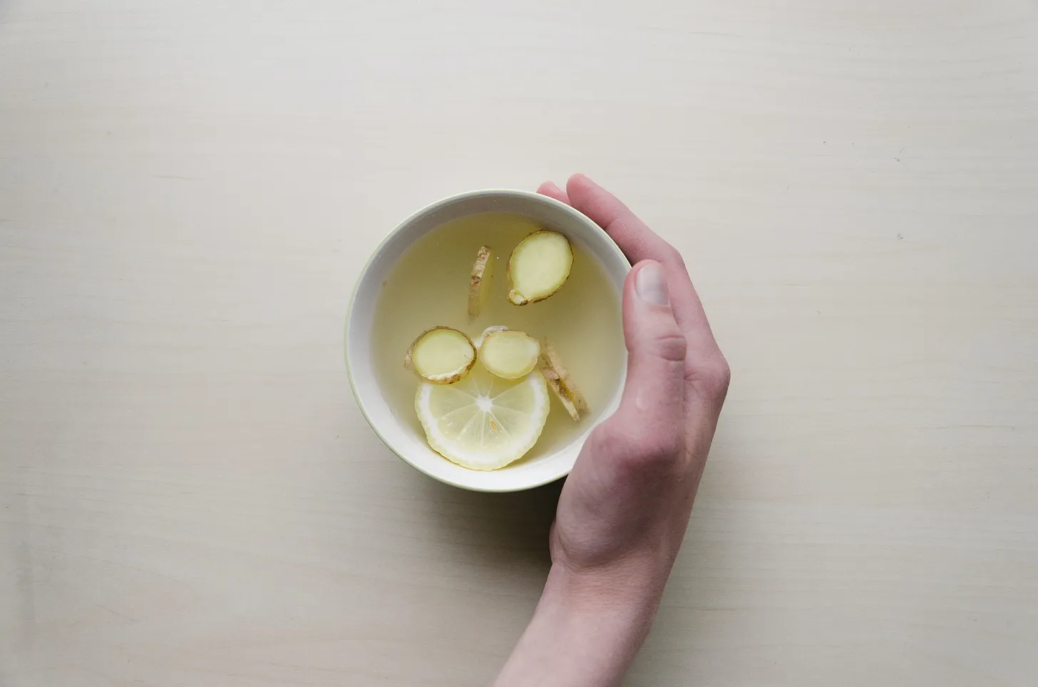 A cup of tea with ginger and lemon in it