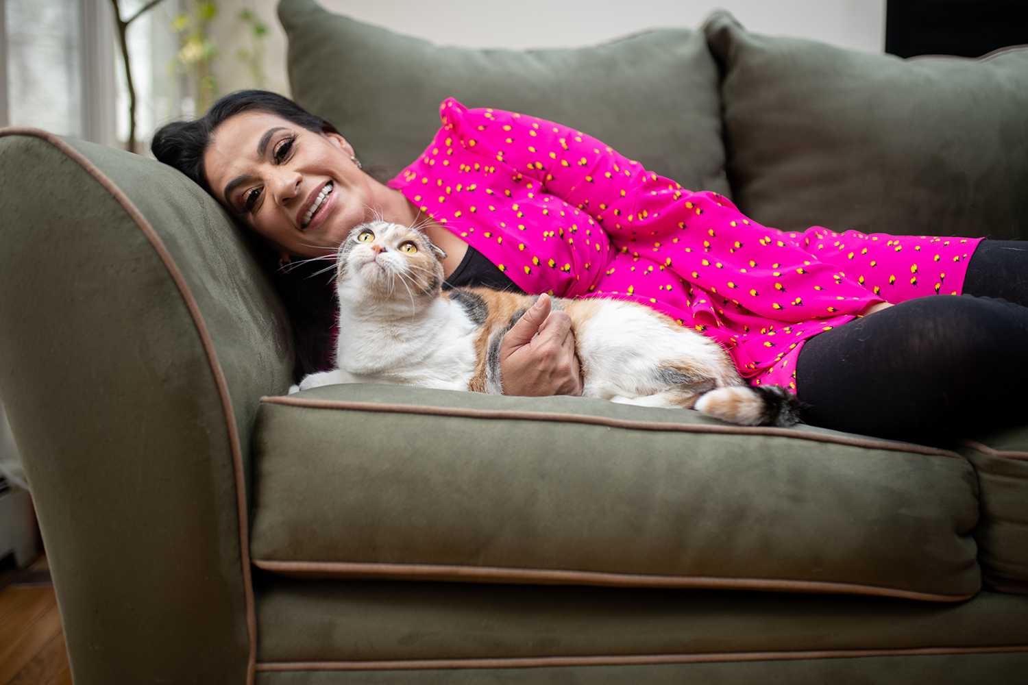 Maysoon Zayid laying on the couch with her cat