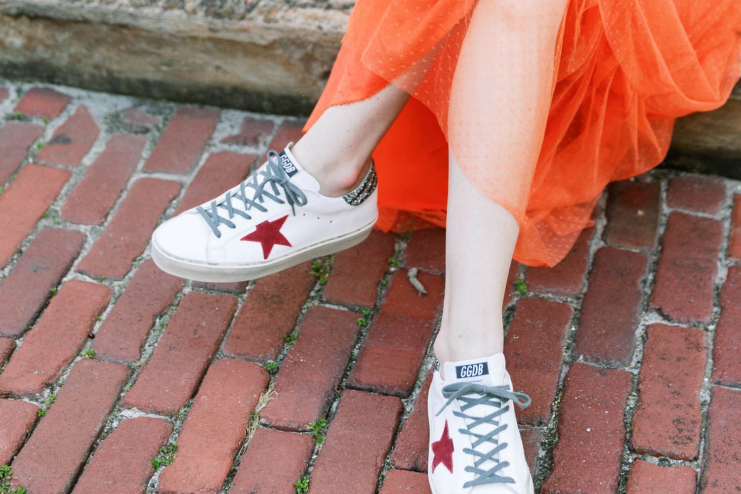 woman in orange-red skirt with sneakers