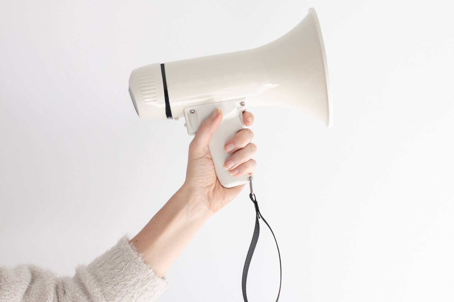 woman's hand holding white blow horn