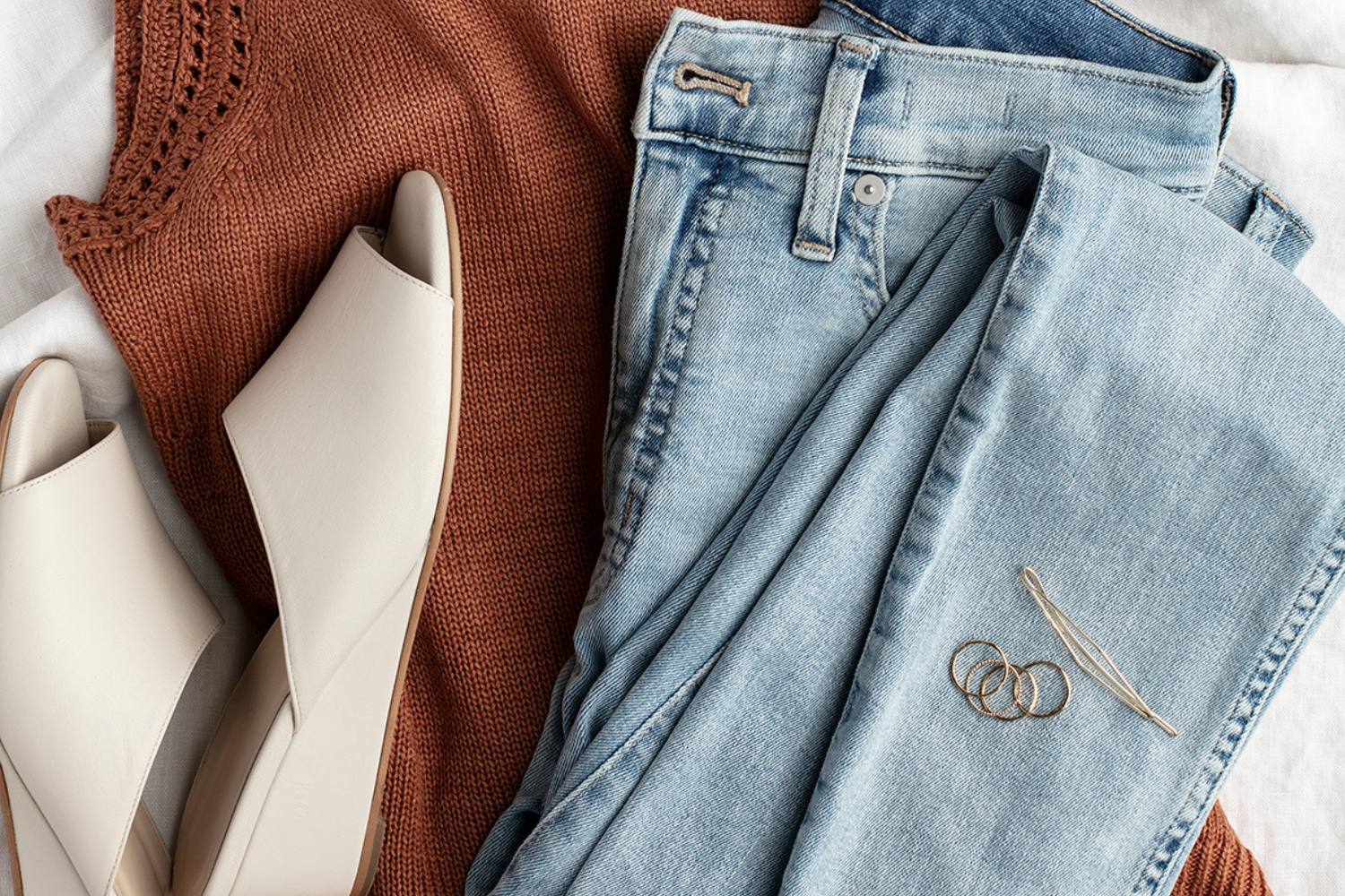 shirt, mule shoe, jeans, earrings and a bobby pin, folded