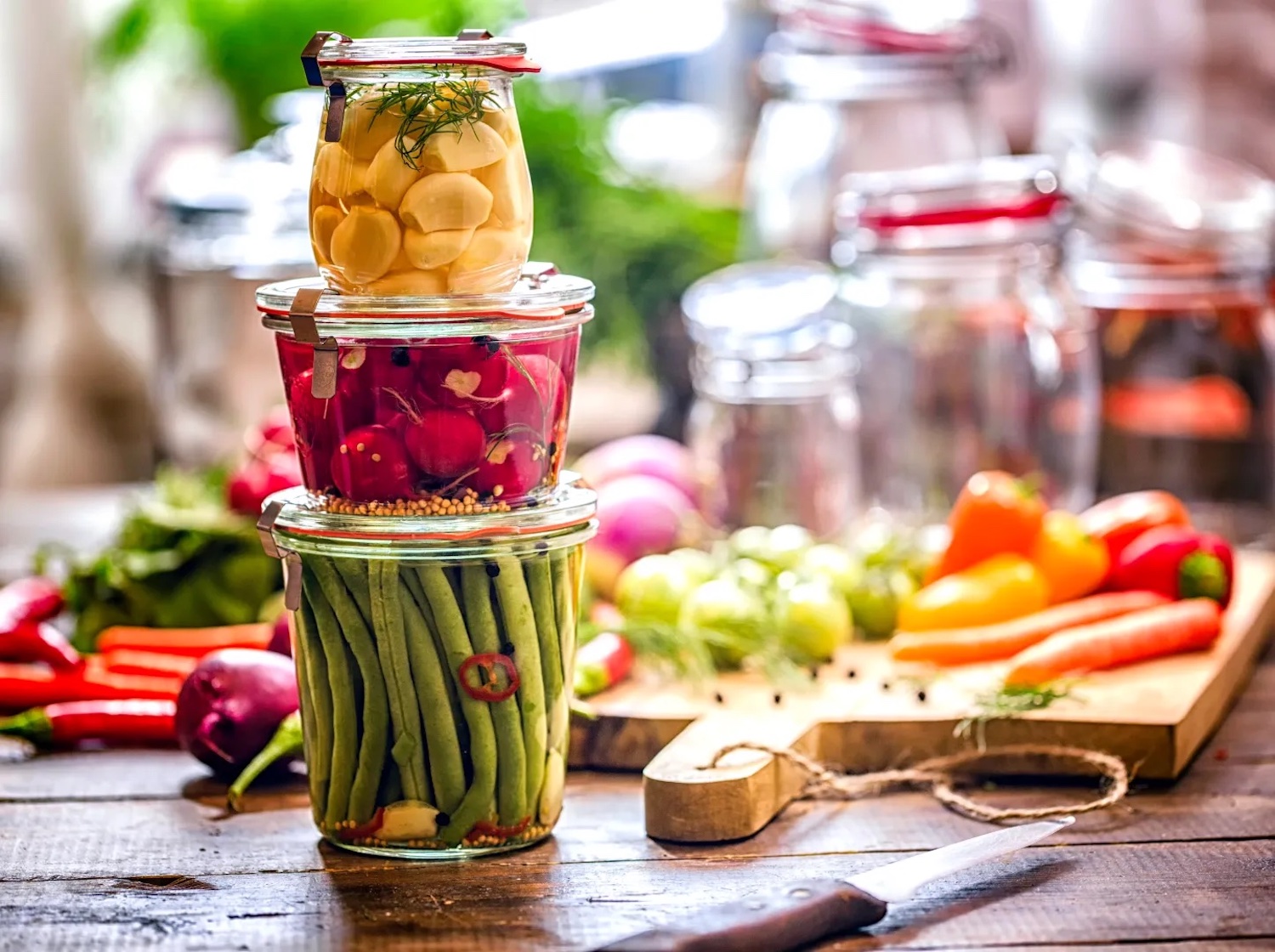 three jars of fermented foods on a kitchen counter