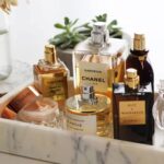 collection of perfumes on vanity, image by stylecaster.com