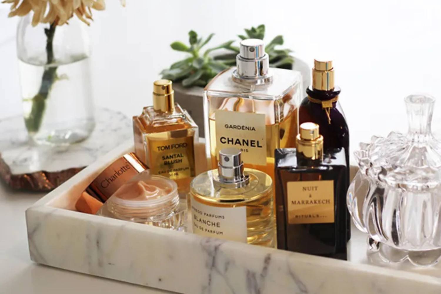 collection of perfumes on vanity, image by stylecaster.com