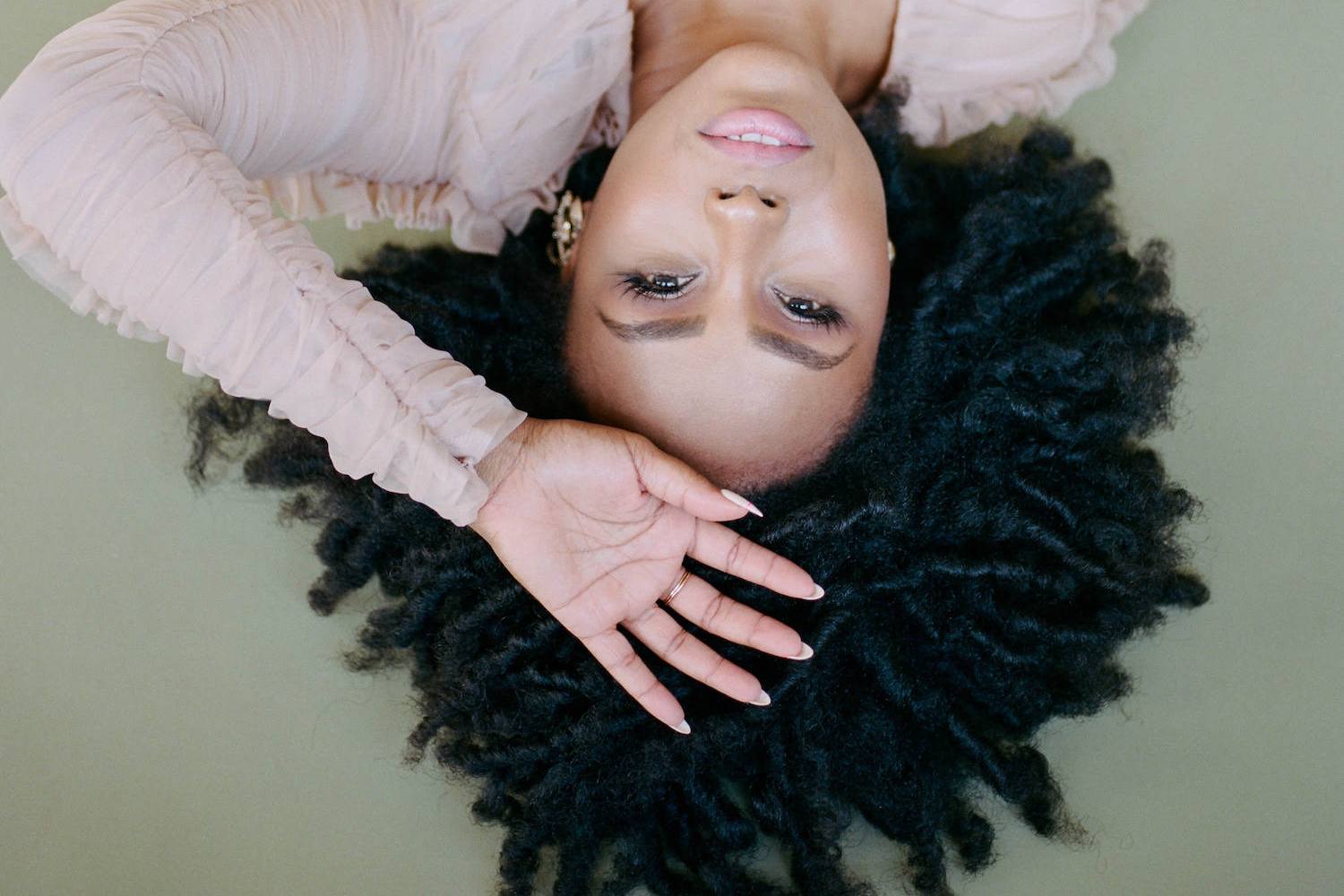 black women facing upsidedown with her hand on her head