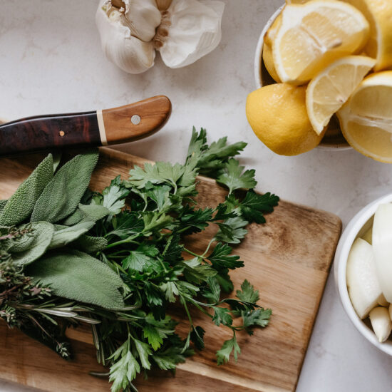 knive and greens on a cutting board, lemon, garlic