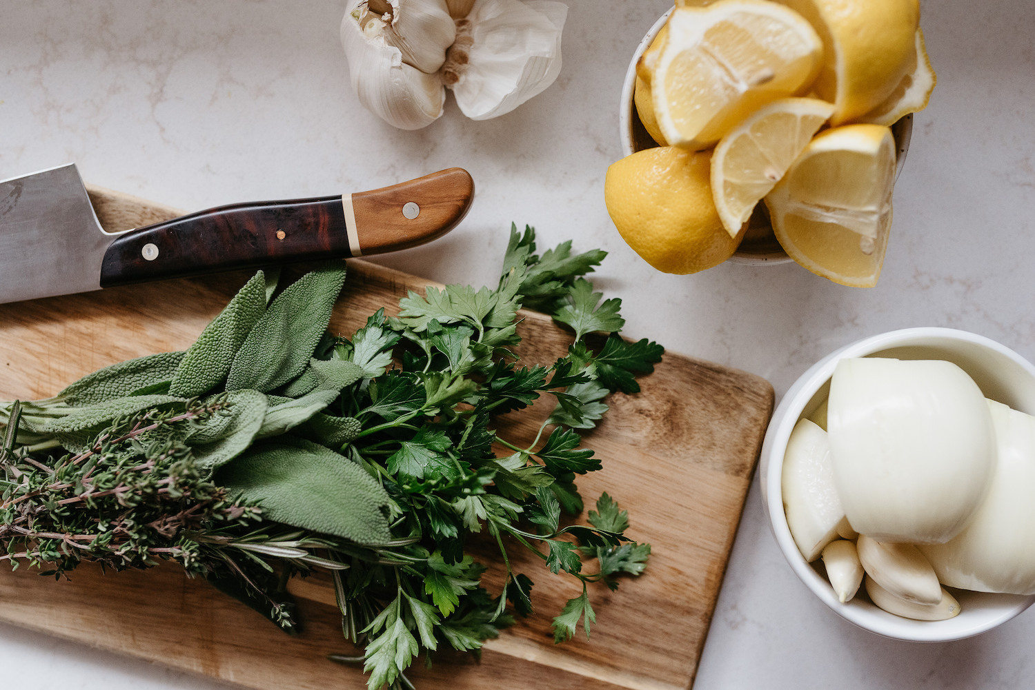 knive and greens on a cutting board, lemon, garlic