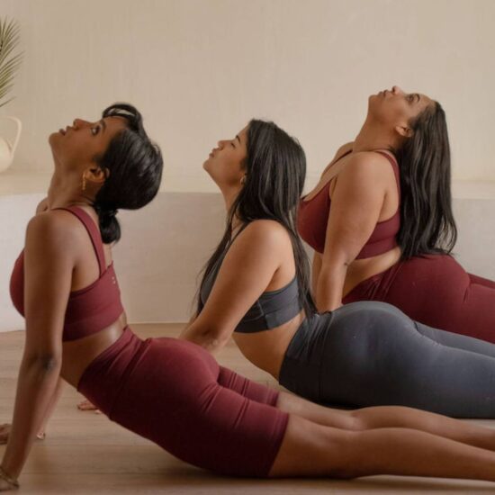 three women in a yoga cobra position