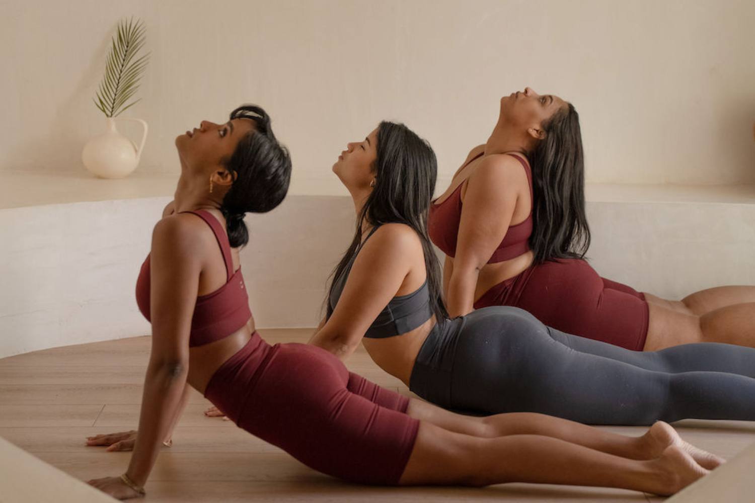 three women in a yoga cobra position