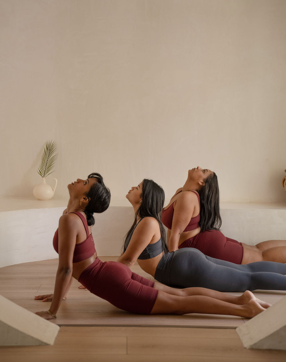 three women in a yoga studio in cobra pose