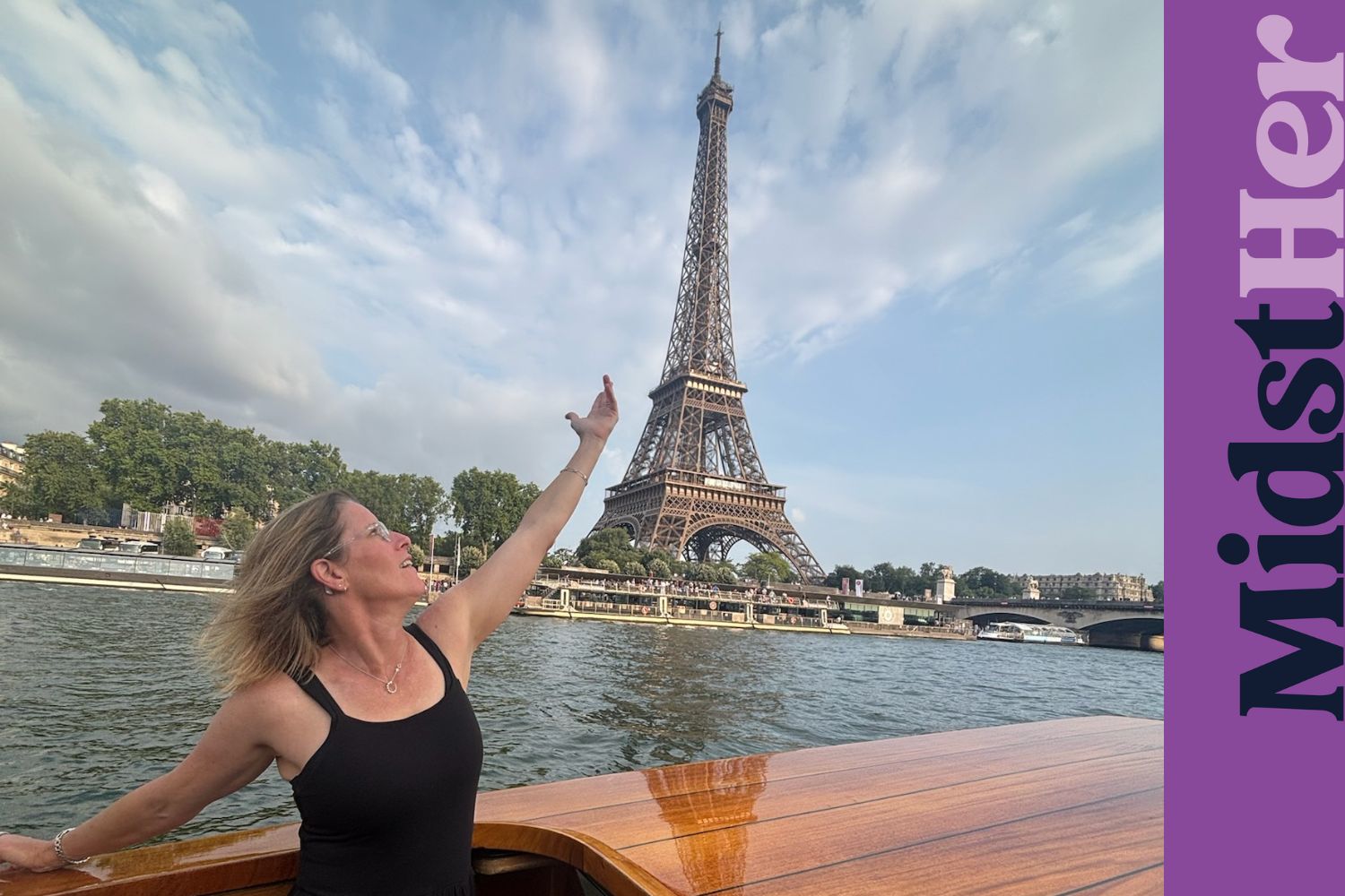 Rebecca Callahan on a boat reaching toward the Eiffel Tower