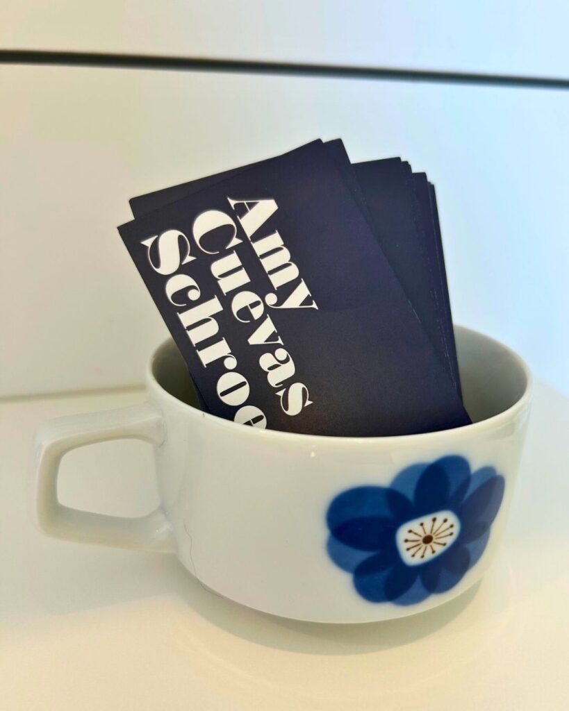 A photo of Amy Cuevas Schroeder's business cards in a tea cup.