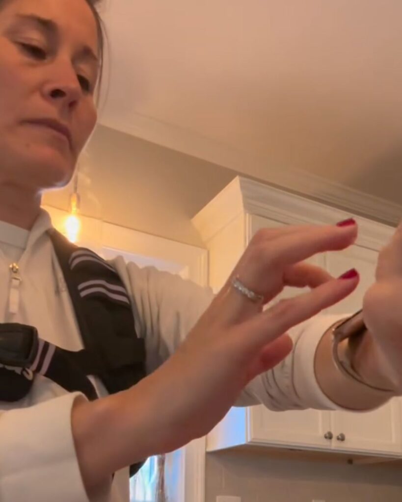A screenshot of a video in which Stella Tamul is using the ChoreFit app on her Apple Watch while cleaning her kitchen