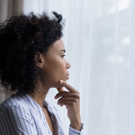 Middle-age Black woman looking out a window