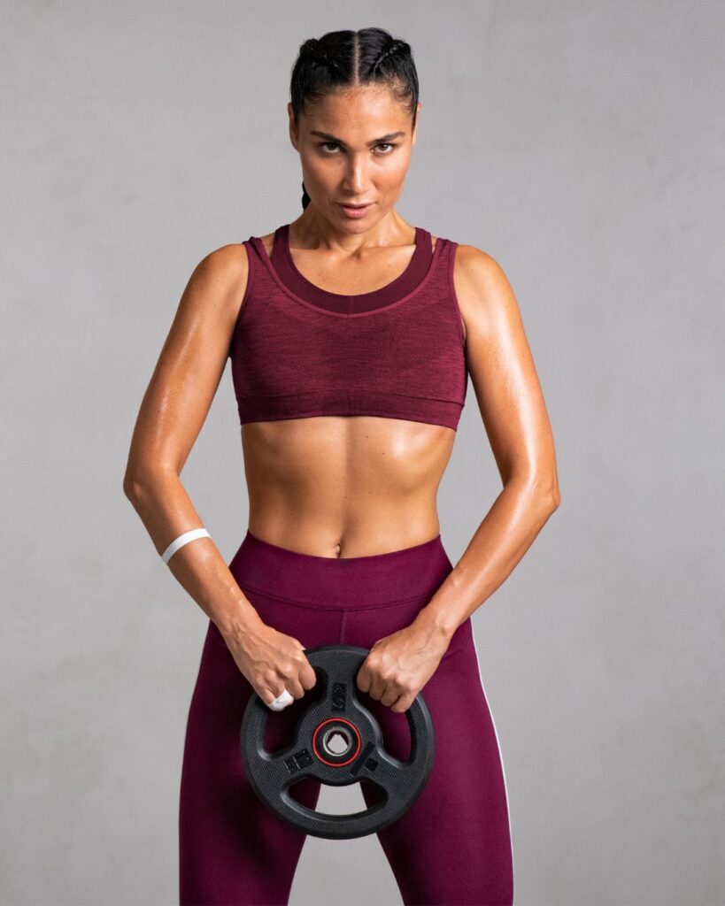 Fit woman with braided hair holding a circular weight